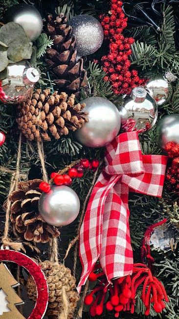 A festive Christmas wreath featuring a lush arrangement of dark green holly leaves with glossy surfaces, interspersed with bright red apples and clusters of red berries. The wreath is decorated with n