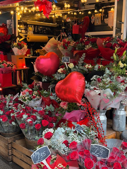 A diverse selection of fresh floral arrangements displayed on a dark surface, featuring various types of flowers including white roses, purple and white eustoma, pink spray roses, and small colorful d